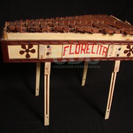 Marimba. Instrumento musical solista. Uso ceremonial y recreativo. Maderas de hormigo, cedro y pinabete, Fibra vegetal, Pintura, Hule y Tripa de cerdo. 84 x 69,5 cms. GUATEMALA.  1979